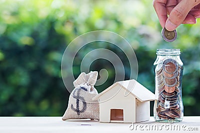 Home loan, mortgages, debt, savings money for home buying concept : Hand holding coin over glass jar. US dollar in a money bag, Stock Photo