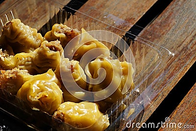 Home made pork dumpling in clear plastic box on wood table with space for write wording Stock Photo