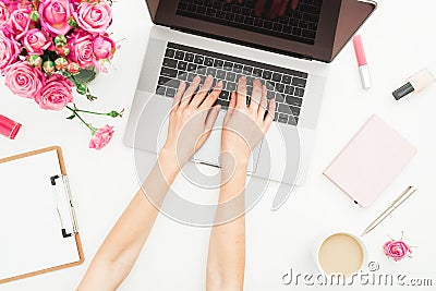 Home office desk. Woman workspace with female hands, laptop, pink roses bouquet, accessories, diary on white. Top view. Flat lay. Stock Photo