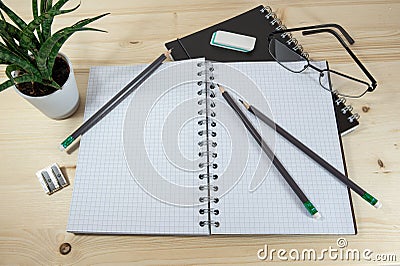 Home office desk for work, study and school with a blank spiral notebook and stationary supplies on a wooden table, copy space Stock Photo