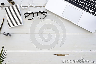 Home office workspace with laptop, glasses, palm leaf, earpligs, notebook and office accessories. Flat lay, top view Editorial Stock Photo