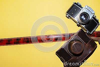 Camera, leather bag and tape for the picture. Yellow background and camera. Design for a photo studio Editorial Stock Photo