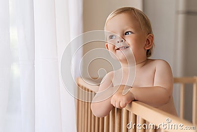 Home portrait of cute little baby boy in bed with pensive face looking at copy space Stock Photo