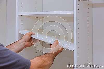 Worker sets the shelf for closet cabinet Stock Photo