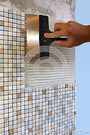 Home repair: installing the mosaic tile on the wall Stock Photo