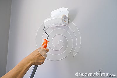 Home repairman paint the walls gray walls, painters use white paint brush rolls Stock Photo