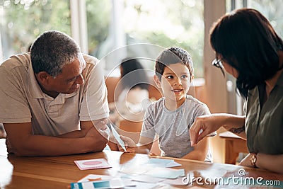 Home school, learning and parents support child with lesson and flash cards for education. Studying, kid and grandfather Stock Photo