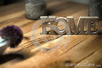 Home sign balanced on wooden table contrast- rest and relaxation Stock Photo