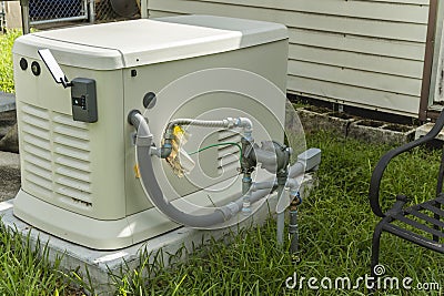 A Home Standby Generator installed at the backyard of a house. An air-cooled natural gas or liquid propane generator for Stock Photo