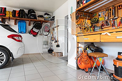 Home suburban car garage interior with wooden shelf, tools equipment stuff storage warehouse on white wall indoor Stock Photo