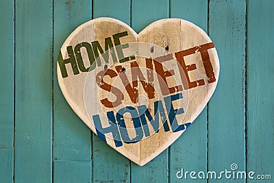 Home Sweet Home message wooden heart on turquoise painted background Stock Photo