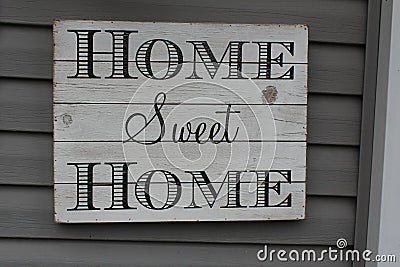 Home Sweet Home sign weathered and hanging on a house. Stock Photo