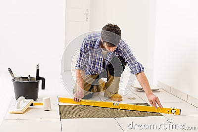 Home tile improvement - handyman with level Stock Photo