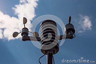 Home weather station on a background of blue sky with the sun behind the clouds. Measurement of temperature, humidity and wind dir Stock Photo