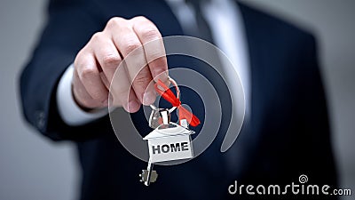 Home word on keychain in businessman hand, house purchase, rental services Stock Photo