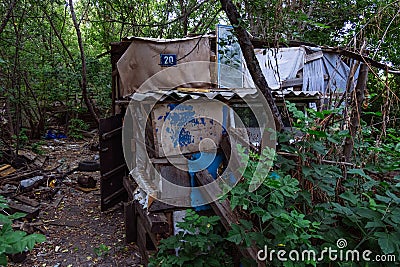 Homeless dweling. Small habitation made from garbage in dirty littered forest Editorial Stock Photo