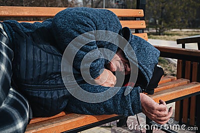 homeless elderly old man lies sleeping on park bench in autumn Stock Photo