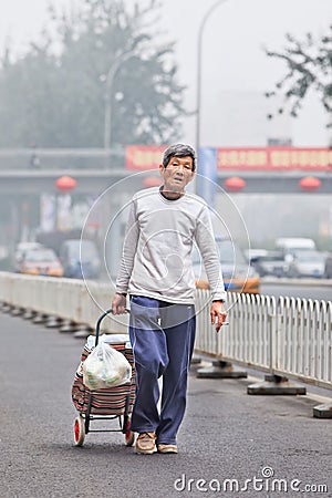 Homeless elderly in smog blanketed city, beijing, China Editorial Stock Photo