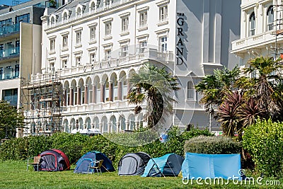 Homeless image with shelter tents against an expensive hotel background Editorial Stock Photo