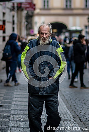 A homeless man covered in drool and dirt walks through the streets of Prague on a cold spring day Editorial Stock Photo