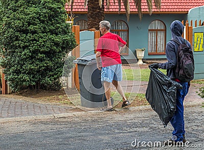 Homeless man picks refuse bins in South Africa Editorial Stock Photo