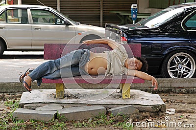 Homeless man sleep on bench on urban background. Beggar on street. Living on streets. Poverty. Helping those less Editorial Stock Photo