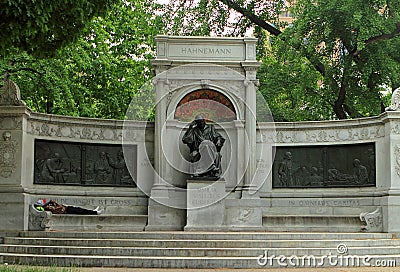 A homeless man taking a nap on the bench of Samuel Hahnemann Monument Stock Photo