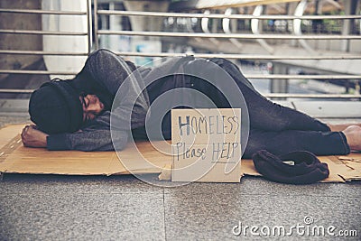 Homeless people poverty beggar man asking for money job and hoping help in helpless dirty city sitting with sign of cardboard box Stock Photo