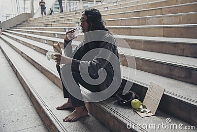 Homeless people poverty beggar man asking for money job and hoping help in helpless dirty city sitting with sign of cardboard box Stock Photo