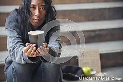 Homeless people poverty beggar man asking for money job and hoping help in helpless dirty city sitting with sign of cardboard box Stock Photo