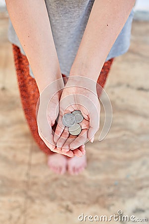Homeless Poor girl asks for money. Outstretched hands with a dime Stock Photo