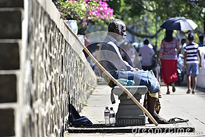 A HOMELESS POOR MAN SEATED ALONE Editorial Stock Photo