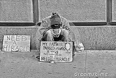 21.05.2016. Homeless poor person in front of Wall Street Stock Excange building ask help and money in Manhattan, New York City, US Editorial Stock Photo