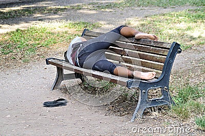 Homeless taking a resti on a bench Stock Photo