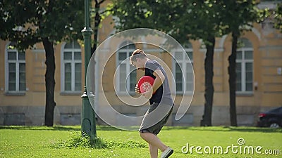 Homem caucasiano considerável que joga o frisbee vermelho fora video estoque Homem caucasiano considerável que joga o frisbee vermelho fora video estoque