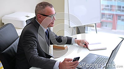 Homem de negócios idoso que trabalha com o computador no escritório moderno vídeos de arquivo Homem de negócios idoso que trabalha com o computador no escritório moderno vídeos de arquivo