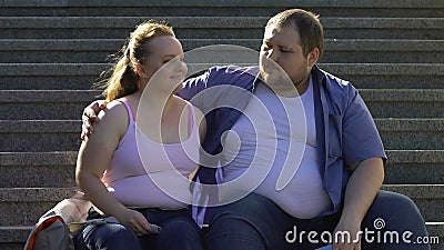 Homem excesso de peso que abraça sua amiga bonita, descansando na data exterior das escadas filme Homem excesso de peso que abraça sua amiga bonita, descansando na data exterior das escadas filme