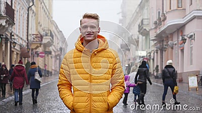 Homem novo que sorri e que olha a câmera Retrato de um homem novo considerável feliz em uma rua urbana filme Homem novo que sorri e que olha a câmera Retrato de um homem novo considerável feliz em uma rua urbana filme