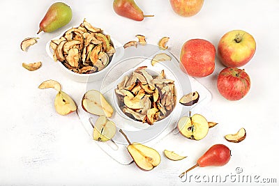 Homemade apple chips in a cup with apples on a white background, in autumn apples are baked in the oven or dryer for storage in Stock Photo