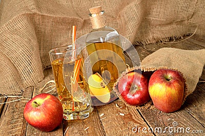 Homemade apple juice with ice, red apples, straw, still life on a wooden table Stock Photo