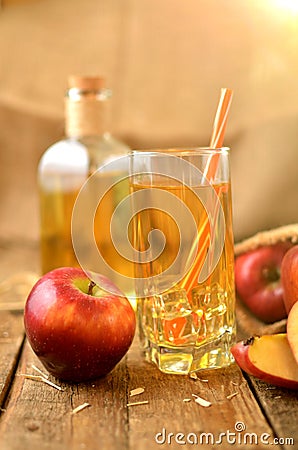 Homemade apple juice with ice, red apples, straw, still life on a wooden table vertical photo Stock Photo