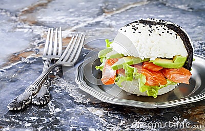 Homemade asian style gluten free sushi salmon burger. Sushi-food hybrids trend. Bright blue background with copy space. Stock Photo