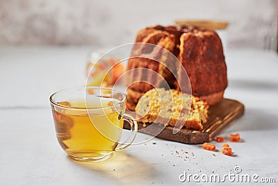 Homemade autumn carrot or pumpkin bundt cake with candied fruits, cup of tea and golden decorative pumpkins Stock Photo