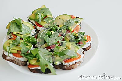 Homemade avocado toast on plate on white countertop in modern kitchen. Healthy eating. Home cooking Stock Photo