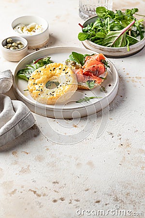 Homemade bagel sandwich with smoked salmon, cream cheese, capers and spinach for healthy breakfast text space Stock Photo