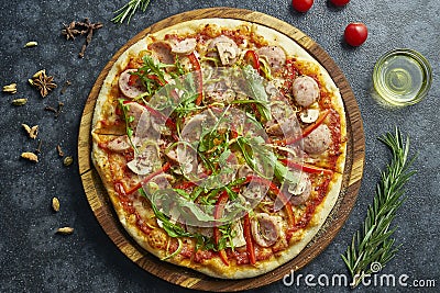 Homemade baked pizza with four kinds of meat, melted cheese, red sauce, tomatoes and ruccola on a black background in a Stock Photo