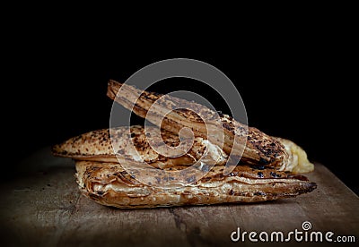 Homemade baking triangular pies with toppings on wooden board on black background Stock Photo