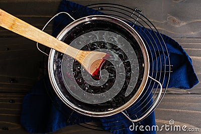 Homemade Blueberry Compote in a Small Pot with a Wooden Spoon Stock Photo
