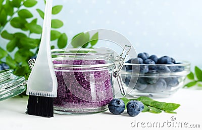 Homemade blueberry face and body sugar scrub/bath salts/foot soak in a glass jar. DIY cosmetics for natural skin care. Copy space. Stock Photo