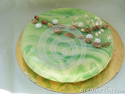 Homemade bright mousse cake with mirror glaze. Marble effect with pistachios Stock Photo